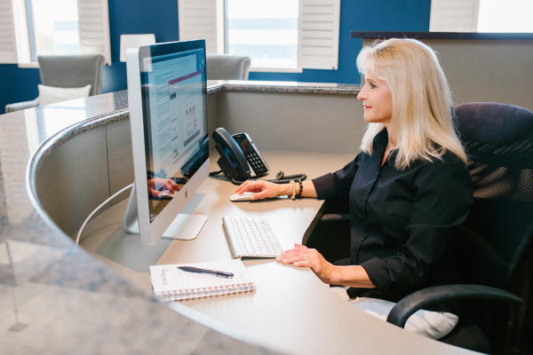 happy employee using computer at front desk