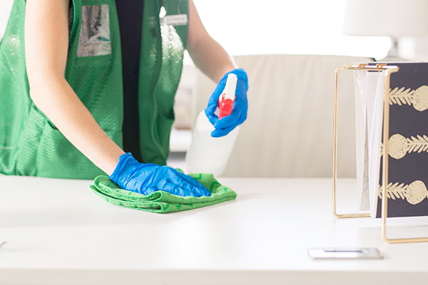 Janitor cleaning office desk surface