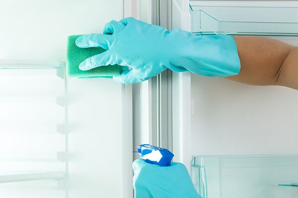 Janitor cleaning office break room refrigerator