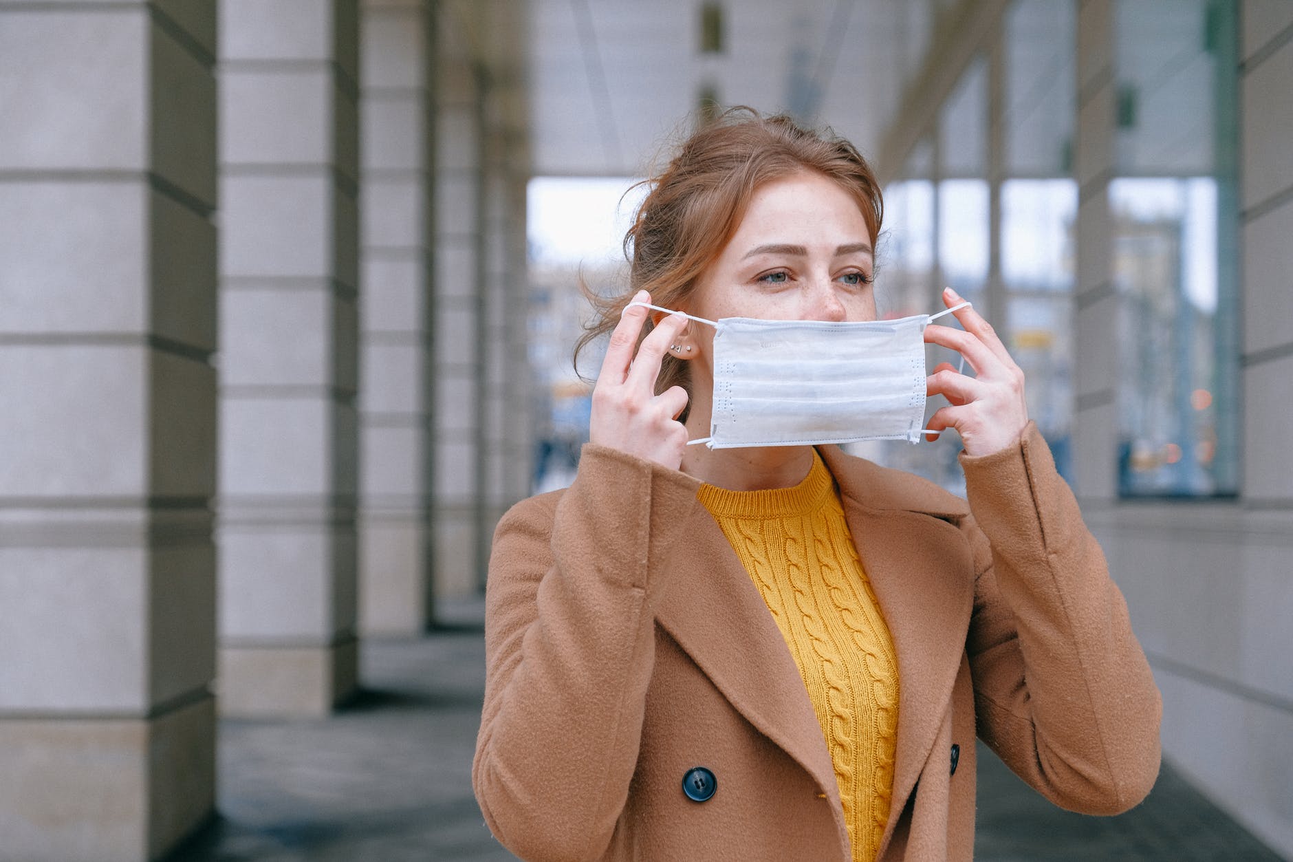 employee putting on medical mask outside
