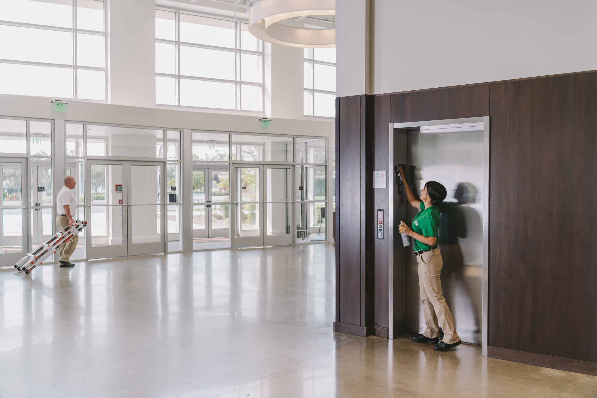 professional cleaner cleaning lobby elevator doorway